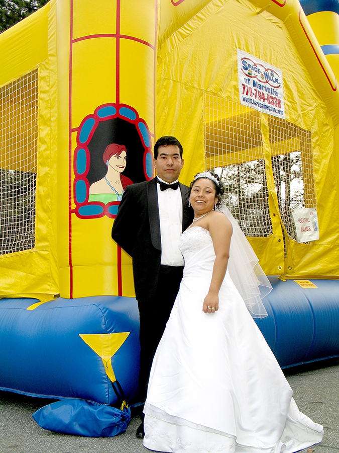 bride and groom with a bounce house